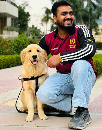 Vikas Thakur, IncrediPets professional dog trainer, with a Golden Retriever puppy wearing a body harness